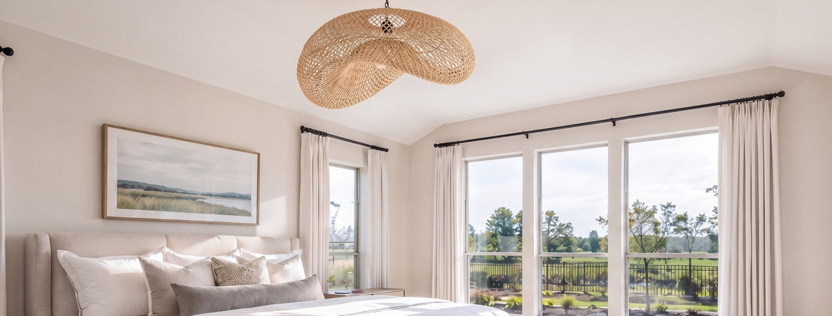 Chambre lumineuse avec suspension tressée en rotin au-dessus du lit